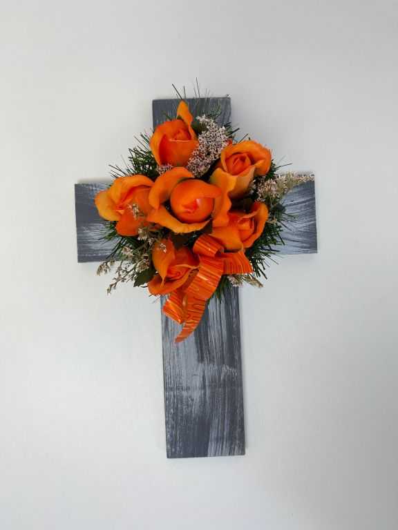 Kříž s umělou květinou v oranžové barvě